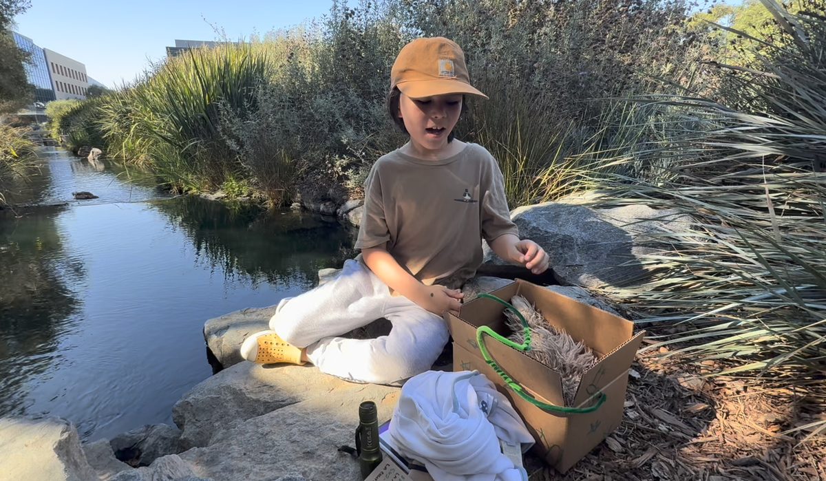 Jefferey inspecting a wildlife rescue kit by a creek